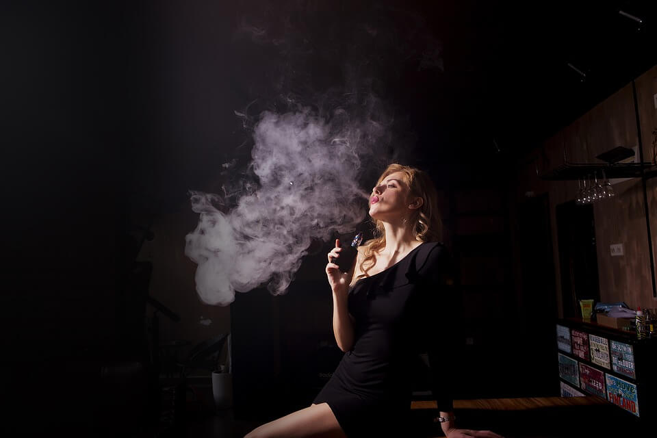 Девушка курит электронную сигарету